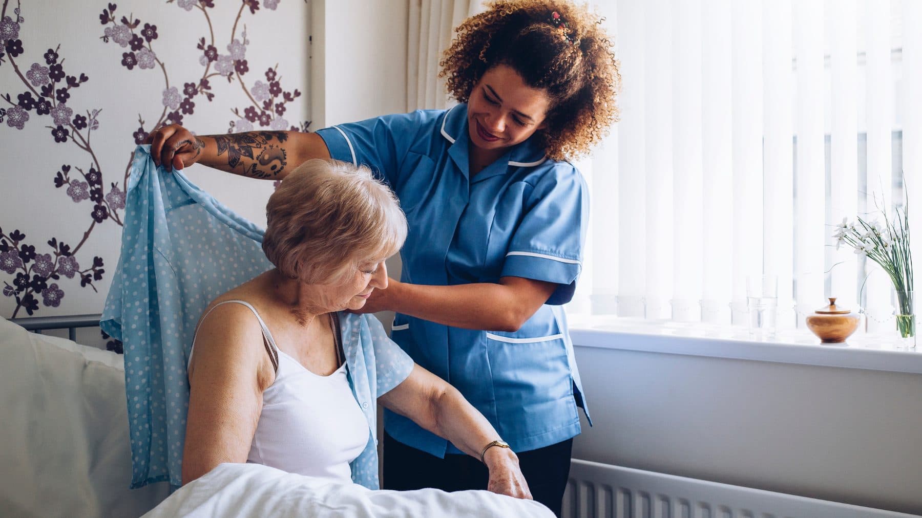 A Comprehensive Care Services carer helping an older woman get dressed at home